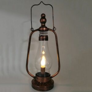 Steampunk portable lamp with distressed bronze metal frame and LED candle bulb, front low-angle view on grey studio background