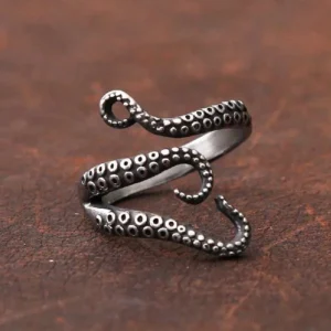 Adjustable kraken tentacle ring showing matte wrap-around design from overhead view on dark wood background
