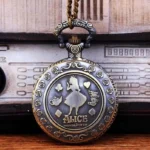 Alice in Wonderland steampunk pocket watch with bronze rose-engraved border, displaying Alice and Cheshire Cat themed engravings, front view on vintage wooden surface