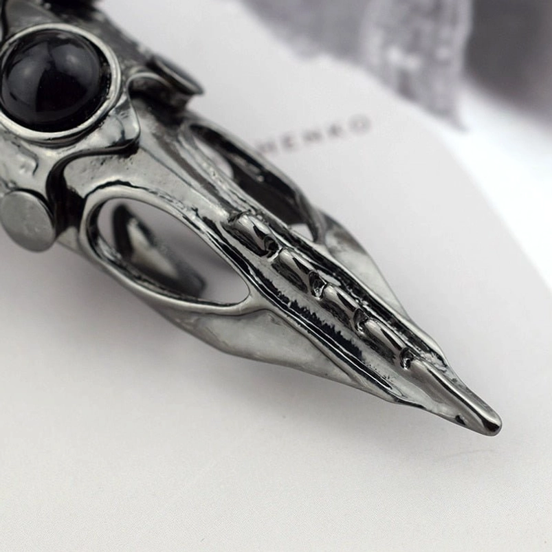 Finger armor ring detailed side angle view showcasing hollow carved metal structure, prominent black gem detail, and industrial gunblack finish