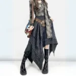 Asymmetrical plaid steampunk gypsy skirt with handkerchief hem worn with faded tie-dye top and brown waist chain, front three-quarter view