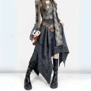 Asymmetrical plaid steampunk gypsy skirt with handkerchief hem worn with faded tie-dye top and brown waist chain, front three-quarter view