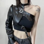 Asymmetrical single-sleeve steampunk cropped leather jacket for women, front-left view showcasing black faux leather construction with metallic buckle straps and industrial hardware details