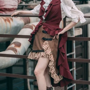 Asymmetrical steampunk skirt with striped ruffle trim and black leather buckles worn by model in outdoor industrial setting