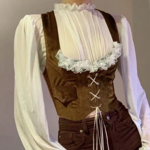 Rich auburn velvet steampunk corset vest with front pocket detail, paired with high-neck ivory ruffle blouse, front three-quarter view