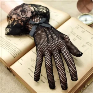 Black fishnet lace Victorian gloves with floral ruffled cuff and satin bow, displayed on single hand over vintage desk with antique books and pocket watch