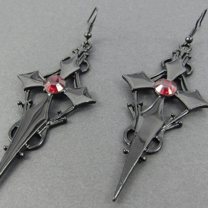 Pair of polished black gothic cross earrings with red central rhinestone and intricate metalwork detail on neutral surface
