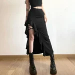 Black gothic fishtail skirt with crisscross lace-up slit and ruffled trim, front three-quarter view on model with tattoos