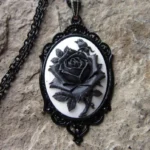 Black rose cameo steampunk necklace pendant with ornate vintage metal frame and black bead chain, close-up detail view