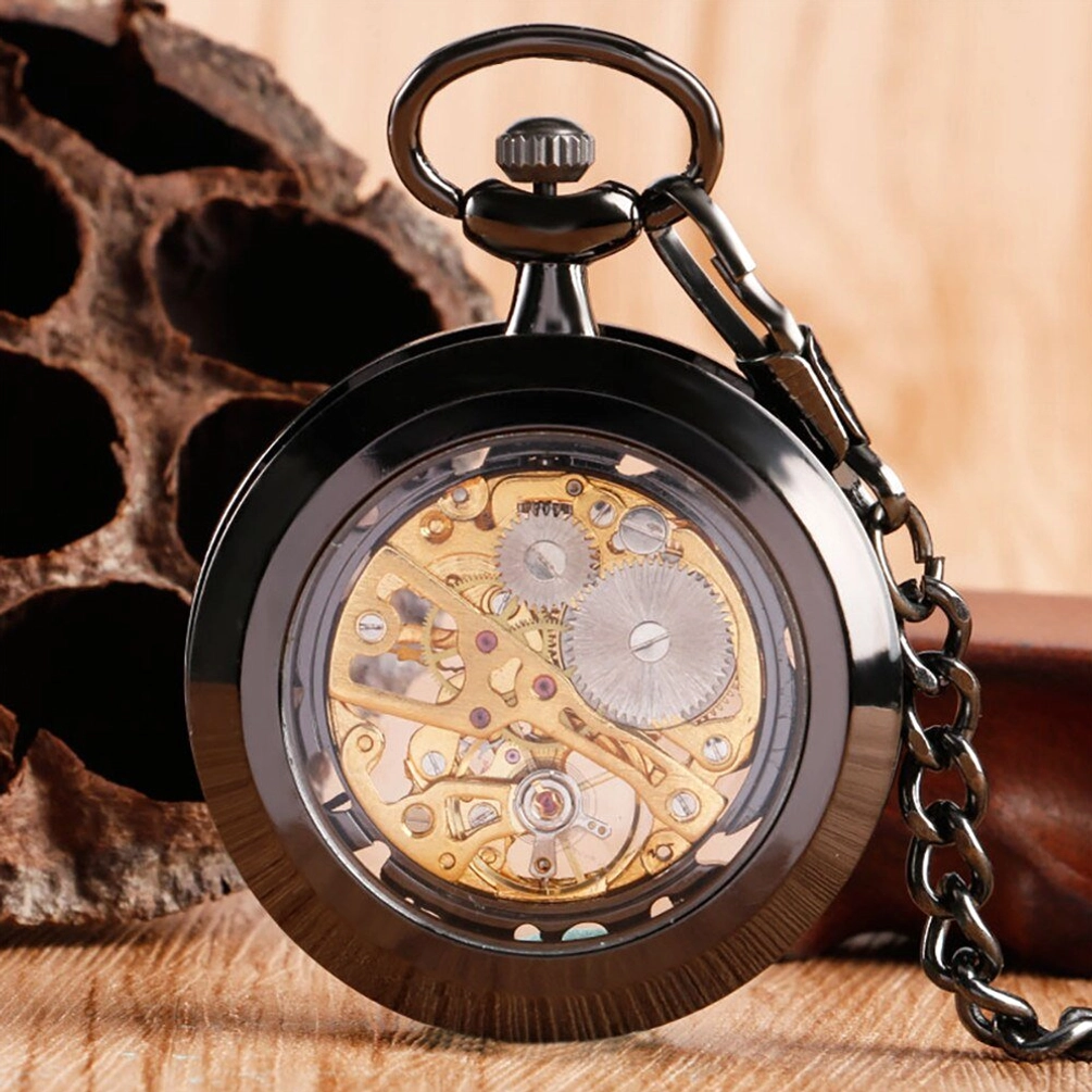 Full black skeleton pocket watch overhead close-up displaying solid black metal case with fully visible mechanical movement and gears