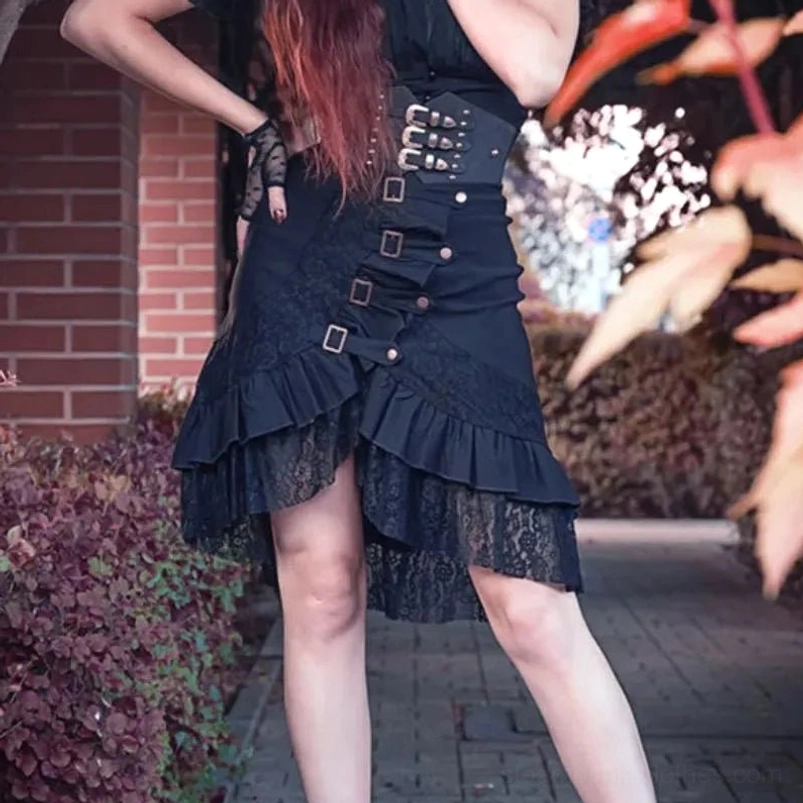 Black steampunk mermaid skirt with multiple front buckles, asymmetrical ruffled lace hem, worn by red-haired model in outdoor garden setting