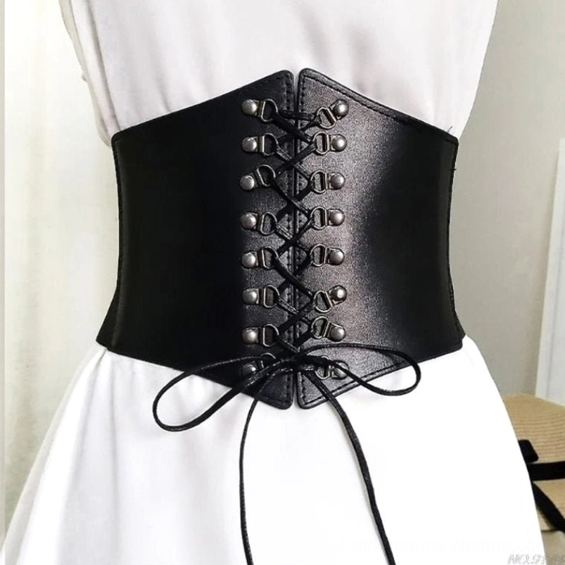 Black laced steampunk corset belt with metal eyelets displayed on dress form, back-oblique perspective showcasing faux leather texture, functional lace-up drawstring detail, and cinched silhouette in white dress styling