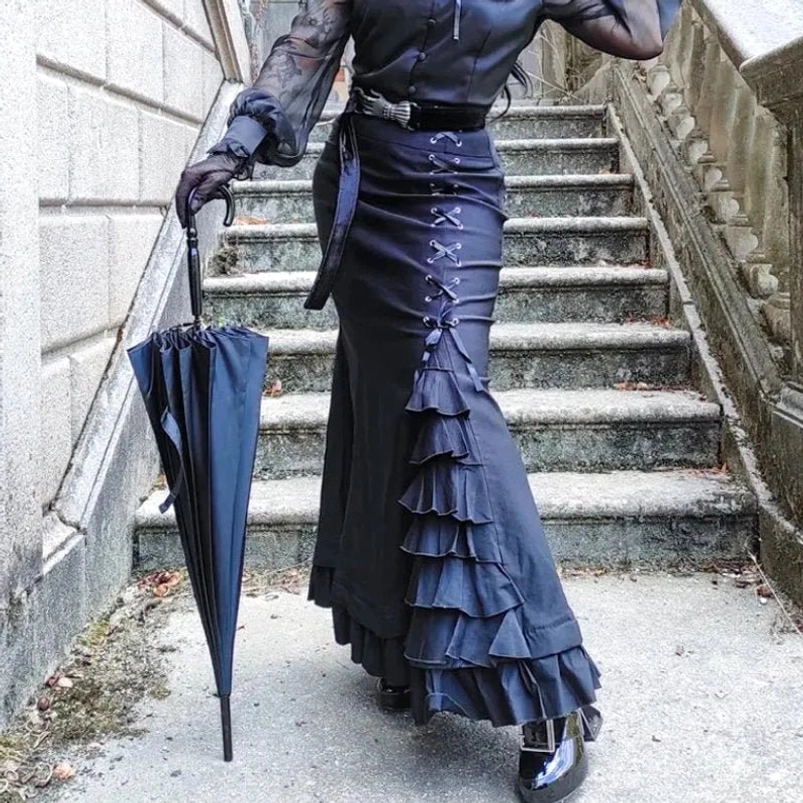 Black steampunk fishtail skirt back view showing dramatic ruffled hem and lace-up side construction with model holding vintage umbrella