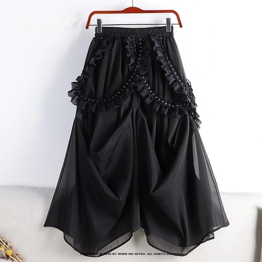 Black gothic steampunk skirt with mesh overlay and studded ruffles displayed on hanger, full front view showing voluminous silhouette and layered construction