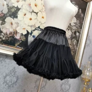 Black multi-layered mesh tulle steampunk skirt three-quarter side angle showing dimensional ruffled edges and sheer overlay construction on mannequin display