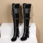 Black Victorian steampunk over-the-knee high heel boots with front lace-up closure and decorative bow accents, displayed on white stepped stand