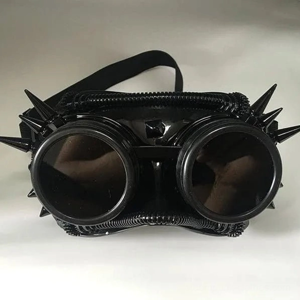 Matte black steampunk welder goggles mask with spike accents, elastic headband visible, front studio shot
