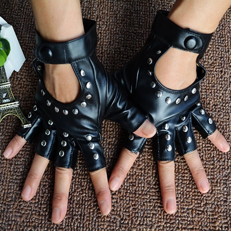 Pair of black fingerless steampunk gloves worn on hands, flat lay overhead view, silver rivets visible, brown carpet background