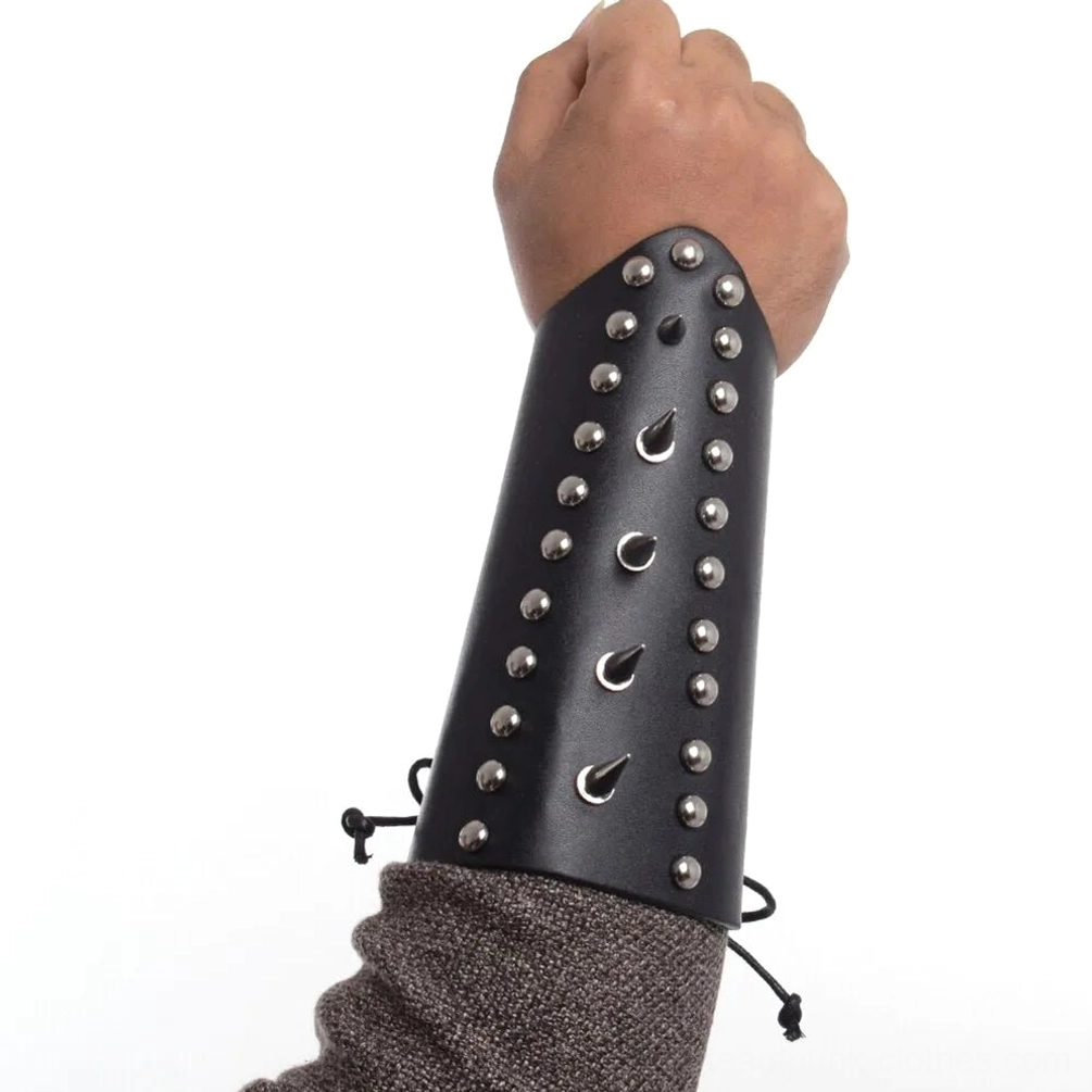 Black studded leather wrist armor with round and teardrop metal rivets worn on male mannequin hand, frontal side view showing stud detail and lace-up fastening system