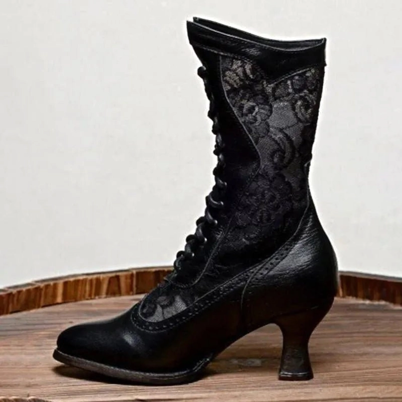 Black Victorian heeled boots with ornate floral lace and leather construction, low angle side view showcasing kitten heel