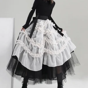 Black and white steampunk ruffled skirt with sheer organza overlay and black tulle underskirt, shown on lower body model from left three-quarter angle, displaying layered ruched frills and mid-calf length