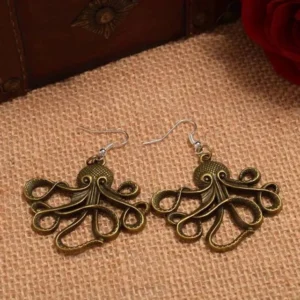 Antique bronze octopus drop earrings side view showing hollowed sculptural design and twisted tentacles, displayed on burlap fabric with ornate antique box and red rose accent