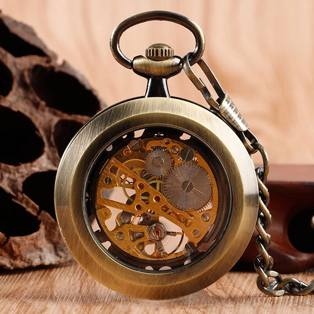 Antique bronze skeleton pocket watch close-up showing detailed internal gear movement and attached vintage pocket chain on wooden surface