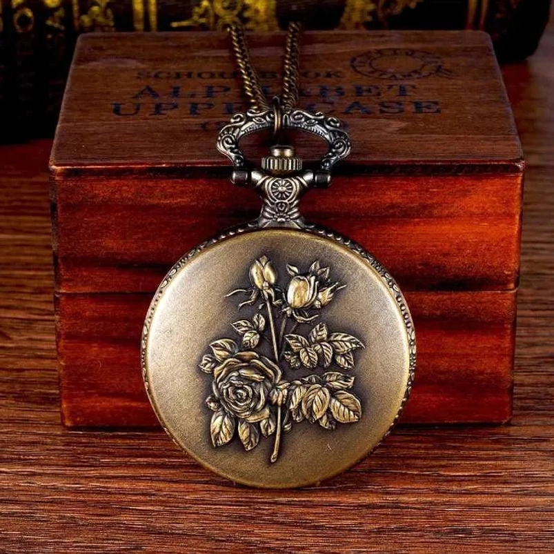 Vintage steampunk pocket watch with embossed rose pattern, bronze metal finish, front view on wooden desktop with retro wooden box, ornate top hook and hardware detail