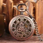 Bronze steampunk pocket watch front view with hollow Roman numeral dial and exposed gear skeleton movement on wooden surface