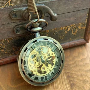 Bronze steampunk skeleton pocket watch with exposed mechanical gears and transparent crystal face displayed on vintage wooden treasure chest