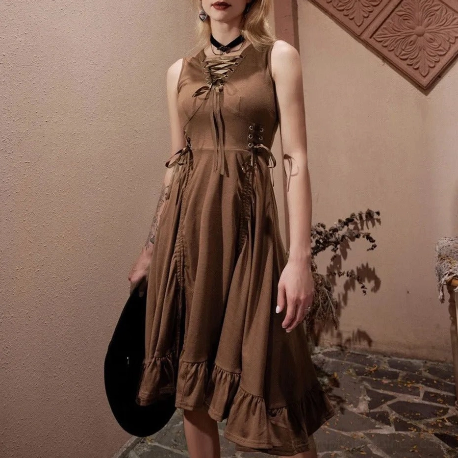 Blonde tattooed model wearing brown steampunk dress with lace-up bodice and black choker in vintage courtyard