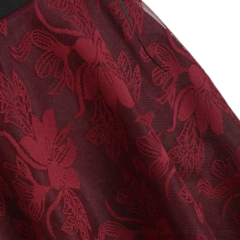 Detailed close-up of burgundy embossed floral pattern on sheer mesh fabric base of steampunk dress
