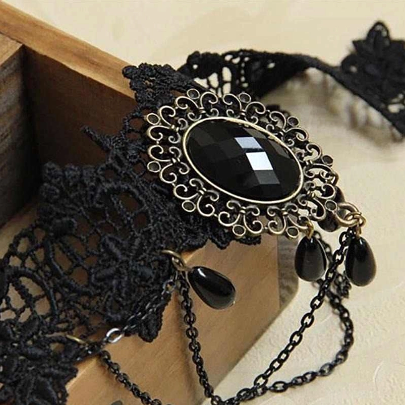 Close-up detailed view of choker components including bronze filigree frame, black gemstone, and teardrop chain pendants