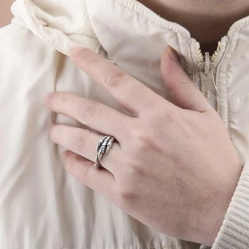 Compact silver claw steampunk ring styled on male hand in casual outfit setting