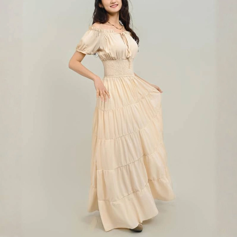 Cream off-shoulder steampunk maxi dress with smocked waist, puff sleeves, tiered skirt, and ruffled trim detail in studio setting