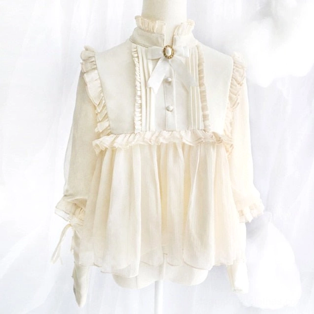 Cream white lolita steampunk blouse front view with ruffled trims, decorative bow brooch at collar and buttoned neckline