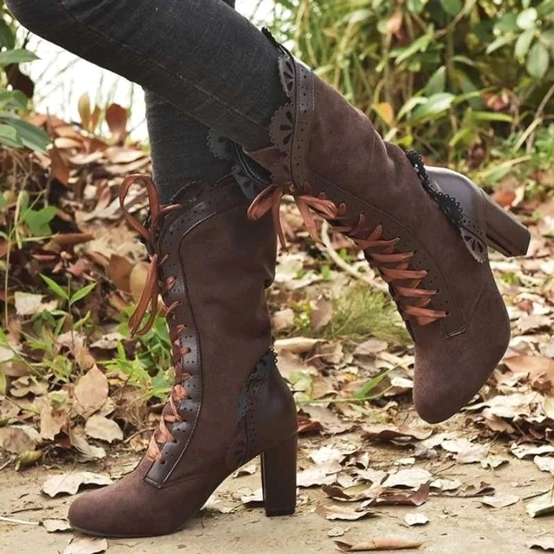 Dark brown suede steampunk boots featuring block heel and front lace-up design, vintage style mid-calf boots worn outdoors with gray jeans