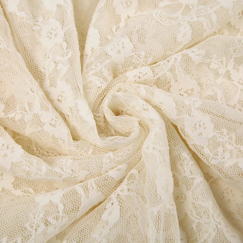 Close-up flat lay of delicate floral lace fabric showing intricate pattern and soft twisted texture detail