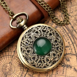 Emerald steampunk pocket watch with bronze hollow carved cover and emerald gemstone inlay, displayed on vintage map background with leather goods and metal chain