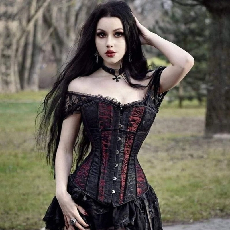 Femme Fatale black and burgundy gothic steampunk corset with floral lace paneling and adjustable back lace-up closure, worn by model in outdoor park setting