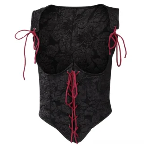 Close-up detail of gothic steampunk corset bodice showing embossed floral jacquard texture, red front lacing system with metal eyelets, and red adjustable shoulder tie straps