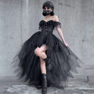 Black gothic high-low tulle steampunk skirt with empire waist, styled with off-shoulder corset top and ruffled trims, worn by short-haired model against concrete wall backdrop