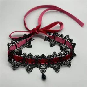 Gothic victorian choker flat lay top view, black floral lace with burgundy velvet ribbon bow and teardrop charm pendant on white background