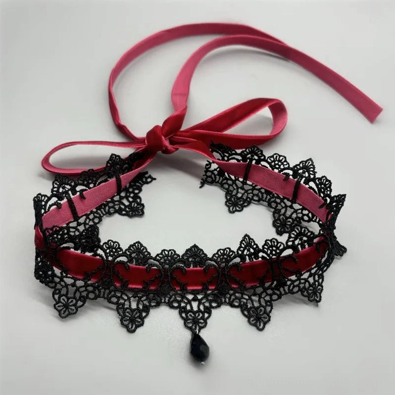 Gothic victorian choker flat lay top view, black floral lace with burgundy velvet ribbon bow and teardrop charm pendant on white background
