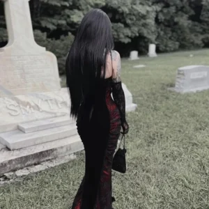 Gothic Victorian mermaid dress back view, showcasing backless strapless design, fishtail floor-length cut, lace chest decoration, and long black gloves in cemetery graveyard backdrop