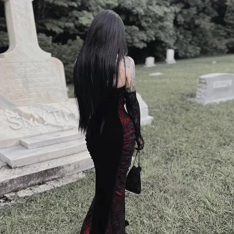 Gothic Victorian mermaid dress back view, showcasing backless strapless design, fishtail floor-length cut, lace chest decoration, and long black gloves in cemetery graveyard backdrop