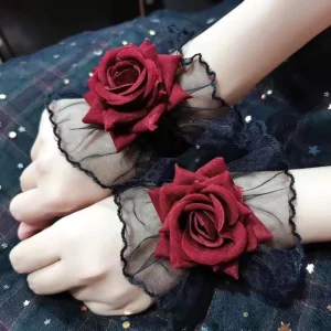 Victorian gothic rose wrist cuffs overhead view with wine-red velvet flocked roses and black sheer mesh ruffles on dark fabric with star embellishments