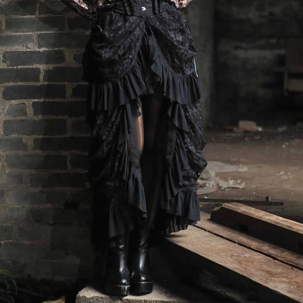 Steampunk high-low skirt front low angle view on model wearing combat boots, industrial brick background, ruffled lace layers visible