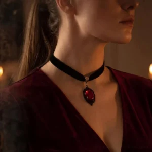 Gothic red gemstone choker worn on side profile showing ornate black metal details and velvet band in warm lighting