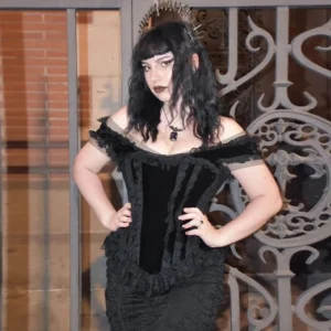 Black velvet off-shoulder gothic corset top with lace ruffles, frontal view on model with halo crown
